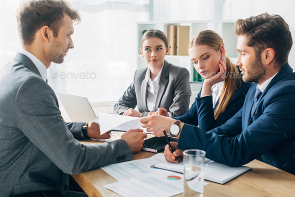 Selective focus of employee with resume during job interview with recruiters in office