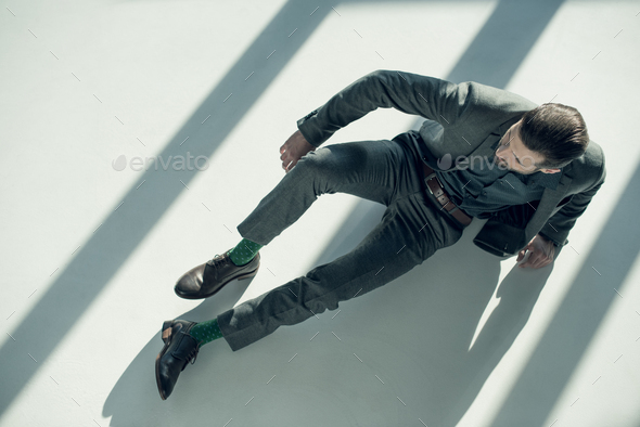 overhead view of handsome stylish man lying on floor