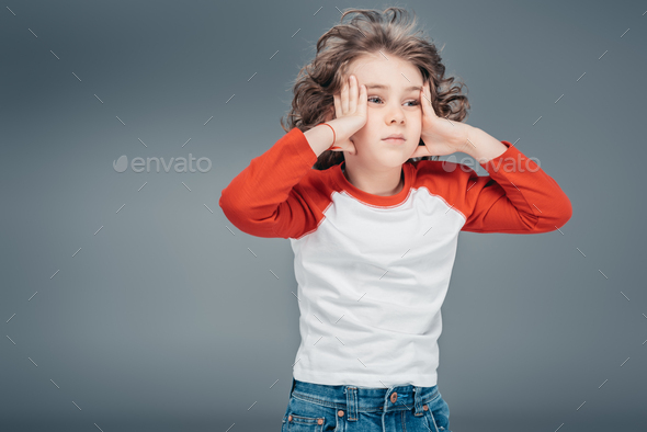 Cute boy touching face by hands isolated on gray background Stock Photo ...