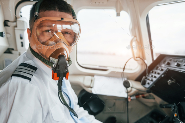 In oxygen mask. Pilot on the work in the passenger airplane. Preparing for takeoff