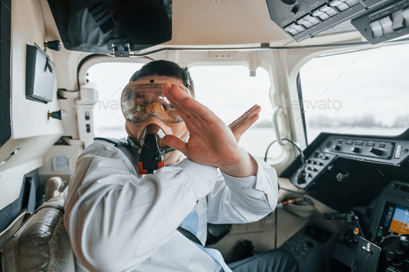 In oxygen mask. Pilot on the work in the passenger airplane. Preparing for takeoff