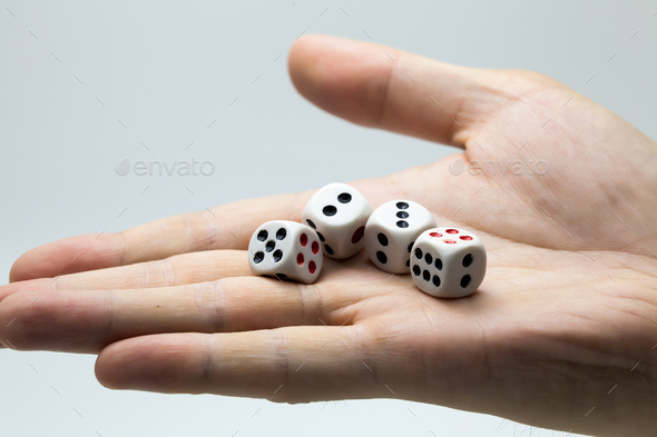 Human hand ready to roll the dice on white isolated background