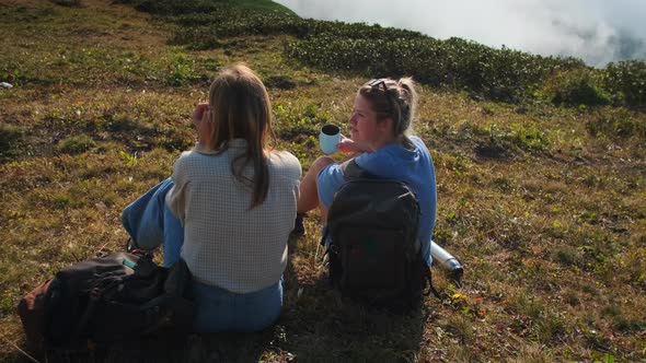 Tourists Rest on Top of Mountain During Backpacking Two Young Women Relaxing alt
