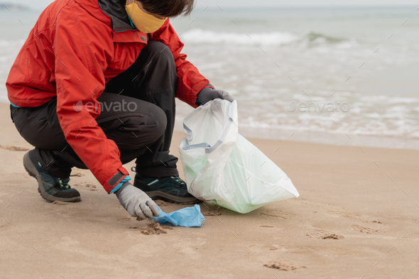 Volunteer collecting plastic waste in the beach for recycling during Coronavirus outbreak