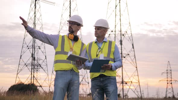 Workers Check Power Lines in Field alt