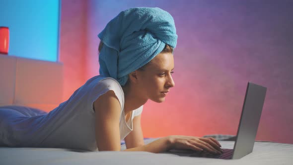 A Attractive Smiling Woman Is Typing Text Message and Using Laptop While at Home alt