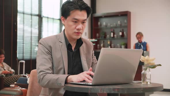 Businessman working on laptop, rushing to Boarding at boarding lounge of airline hub, business trip alt
