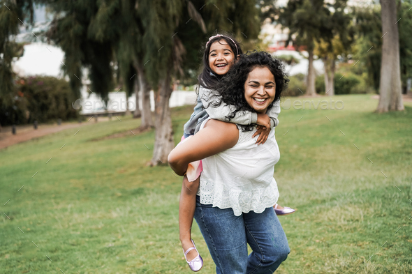 Happy indian mother having fun with her daughter outdoor - Focus on mother  face Stock Photo by DisobeyArtPh