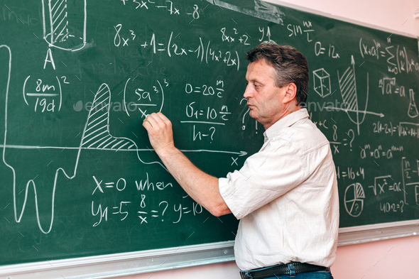 Teacher write on the blackboard and explain a lesson.- Image