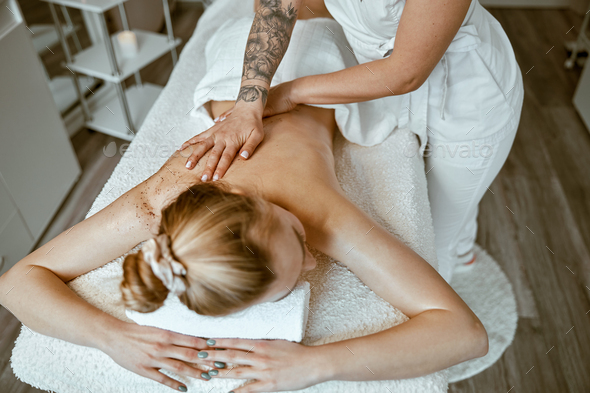 Caucasian woman getting a back massage in the spa salon Stock