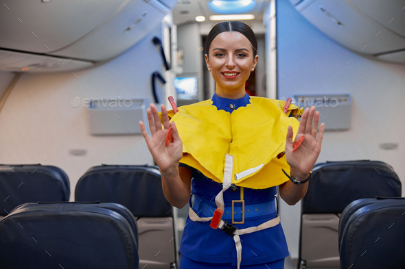 stewardess is showing safety rules before fly at evening plane salon