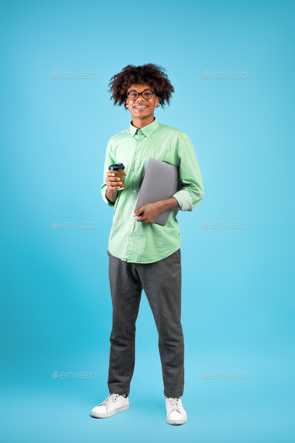 Modern student. Happy black guy with laptop computer, blue background