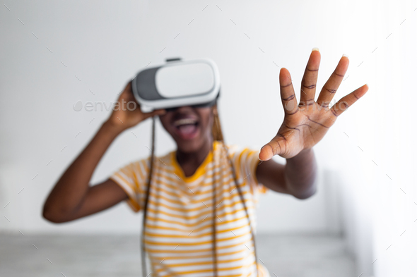 Excited black lady using VR glasses, grabbing something - Stock Photo - Images