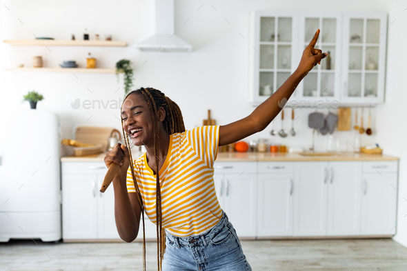 Young black woman having fun while cooking at kitchen - Stock Photo - Images