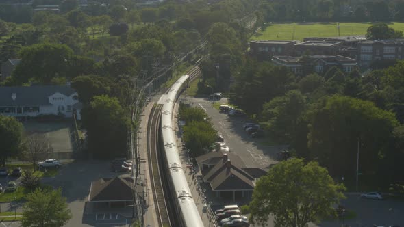 Aerial View of a Train Passing Through Garden City Long Island on a Sunny Day alt