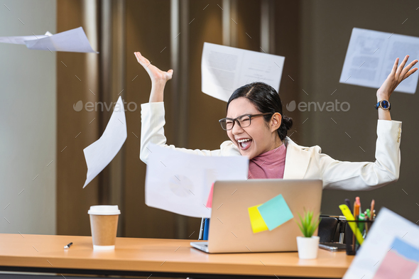 Asian businesswoman angry throwing papers over the herself in office - Stock Photo - Images