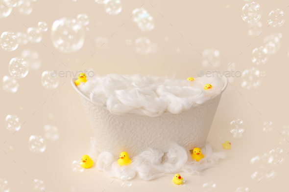 White small bath for a photo shoot of a child on a light background, decorated with ducks.
