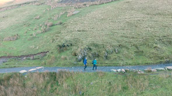 Aerial view of people hiking and climbing Snowdon mount in Wales on a sunny d alt