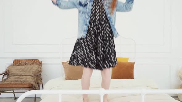 Happy Child Having Fun and Jumping on White Bed alt