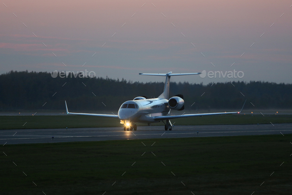 Private jet plane taxiing on the runway in the dark, ready to take off