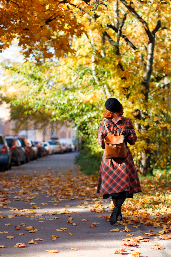 redhead woman walking at city street at sunny day. Autumn mood, foliage concept - Stock Photo - Images
