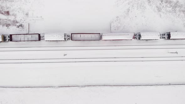 Freight train with wagons in winter, top view alt