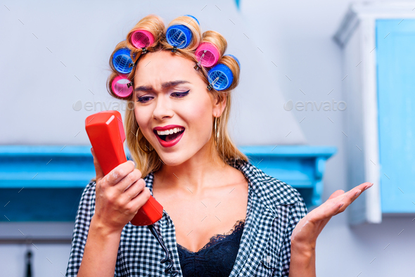 angry housewife in curlers talking on vintage telephone