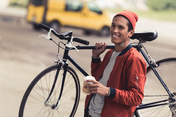 happy stylish man with vintage bicycle and coffee to go