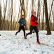 Man and Woman Running Together Through Woods in Winter. - PhotoDune Item for Sale
