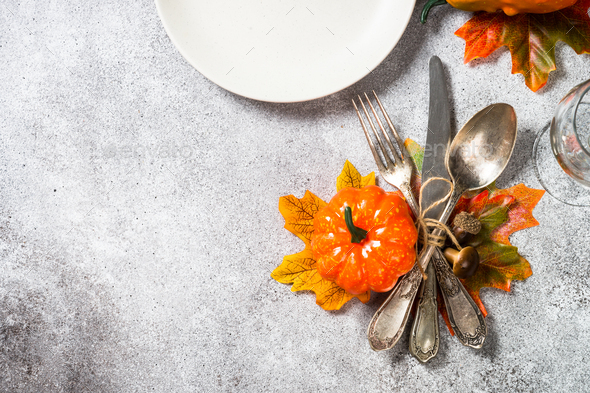 Autumn table setting with white plate, candles and fall decorations - Stock Photo - Images