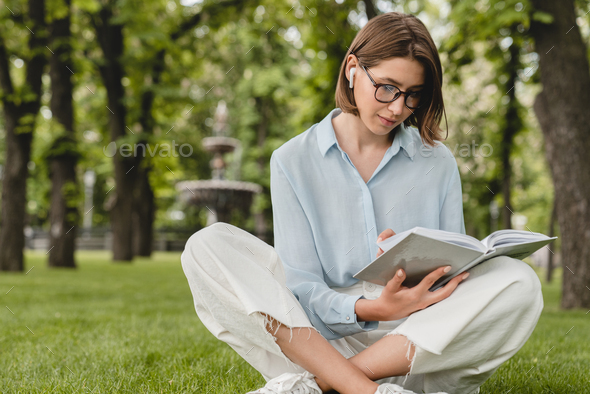 Teenager young beautiful student woman freelacer reading book preparing for educational exam
