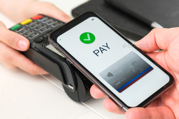 Contactless payment using smartphone by POS payment terminal - Stock Photo - Images