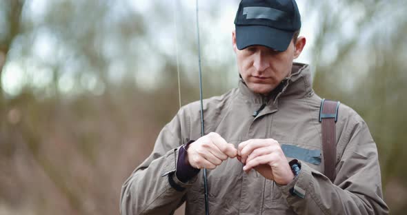 Confident Man Preparing Fishing Rod at Lakeshore alt
