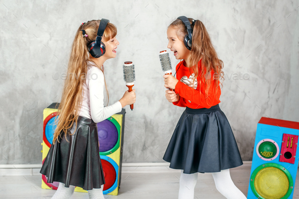 Funny kids singing and listening to music on headphones. The con - Stock Photo - Images