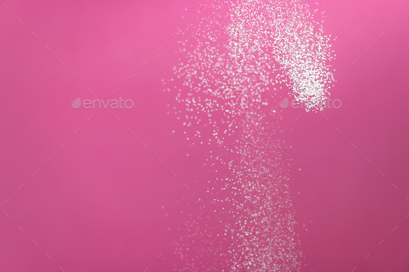 White powder explosion isolated on pink background. Flour sifting on a pink background