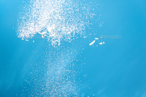 White powder splash isolated on blue background. Flour sifting on a blue background