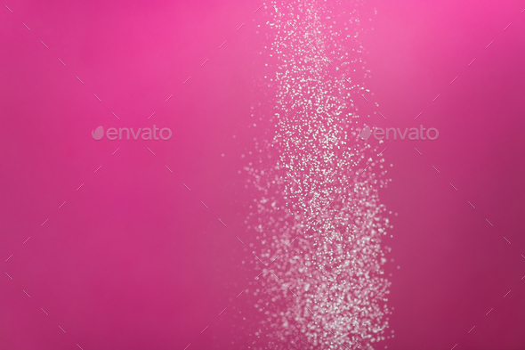 White powder splash isolated on pink background. Flour sifting on a pink background