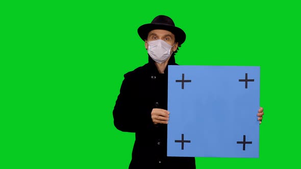 Stylish Adult Man In Mask Moving Towards The Camera With Blue Mockup Board