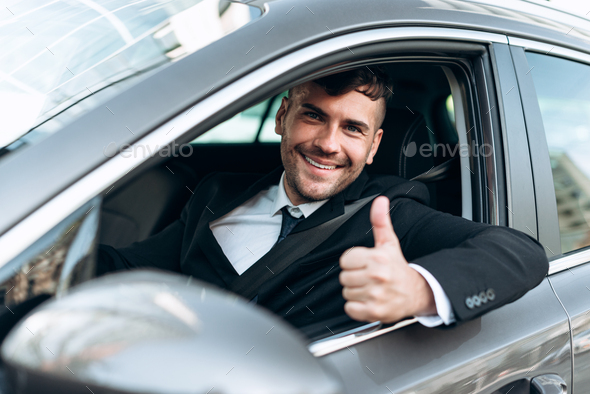 Thumbs up. Portrait of a happy businessman showing thumbs up sitting in ...