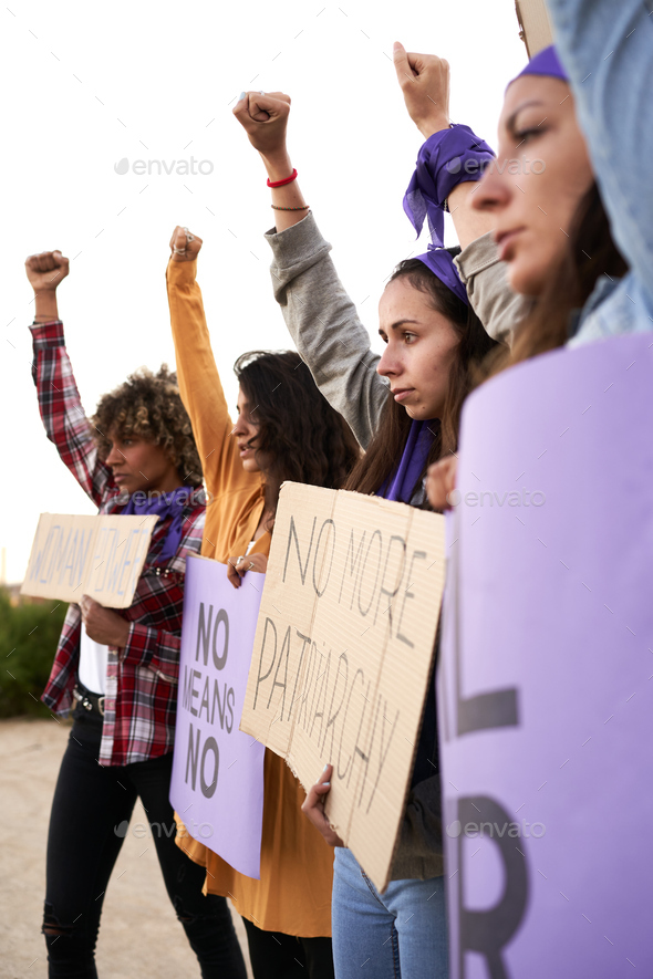 Vertical photo of a group of women marching on the road in protest