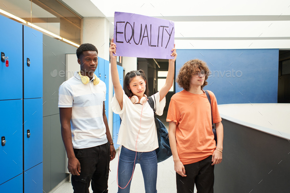 Group of students carrying a banner at school protesting for equality.