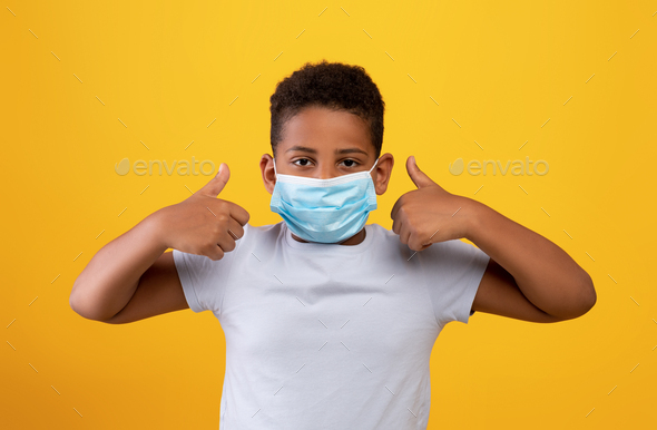 Funny black boy wearing protective face mask, showing thumb ups Stock ...