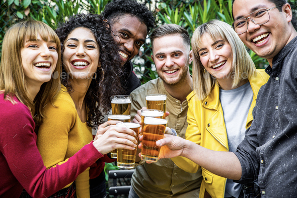 Happy multiracial friends toasting beer glasses at brewery pub Stock Photo  by engy91