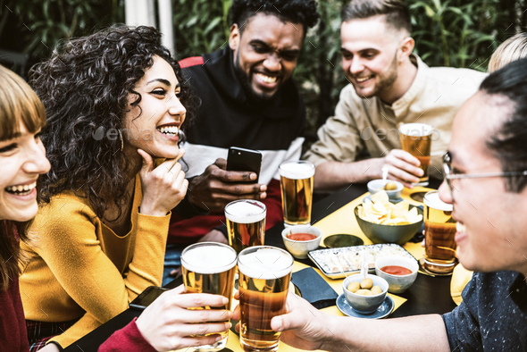 Happy multiracial friends toasting beer glasses at brewery pub Stock Photo  by engy91