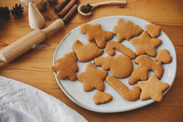 Fresh baked gingerbread cookies in christmas festive shapes on baking tray  in modern white kitchen Stock Photo by Sonyachny