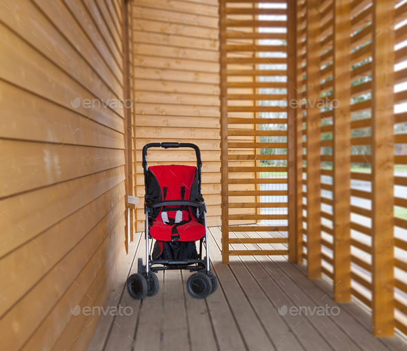 Red child's buggy at the buggy bay at a pre-school or children's day care nursery
