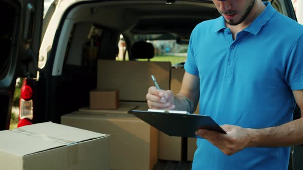 Eshop Courier Signing Documents Counting Parcels in Van Working Outside Alone alt