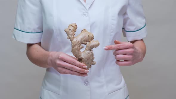 Nutritionist Doctor Healthy Lifestyle Concept - Holding Ginger Root alt