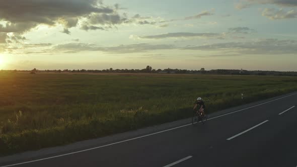 A Cyclist is Riding Fast on the Highway alt