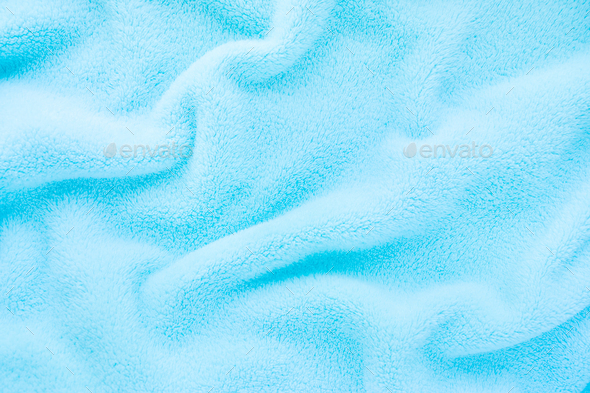 Fluffy baby blue fabric. Soft pastel textile texture. Folds on the